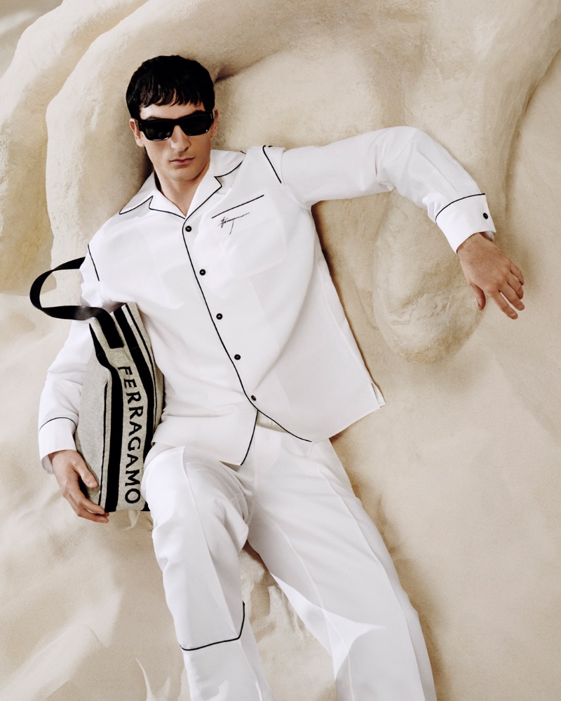 Luca Lemaire presents a sharp contrast in a piped white ensemble for Ferragamo's pre-fall 2024 campaign. 