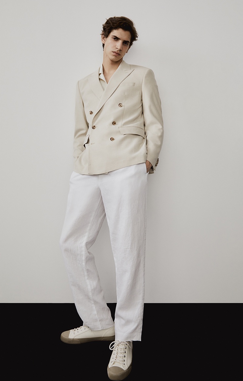 Hedi Ben Tekaya showcases a double-breasted jacket and white linen trousers from H&M's collection.