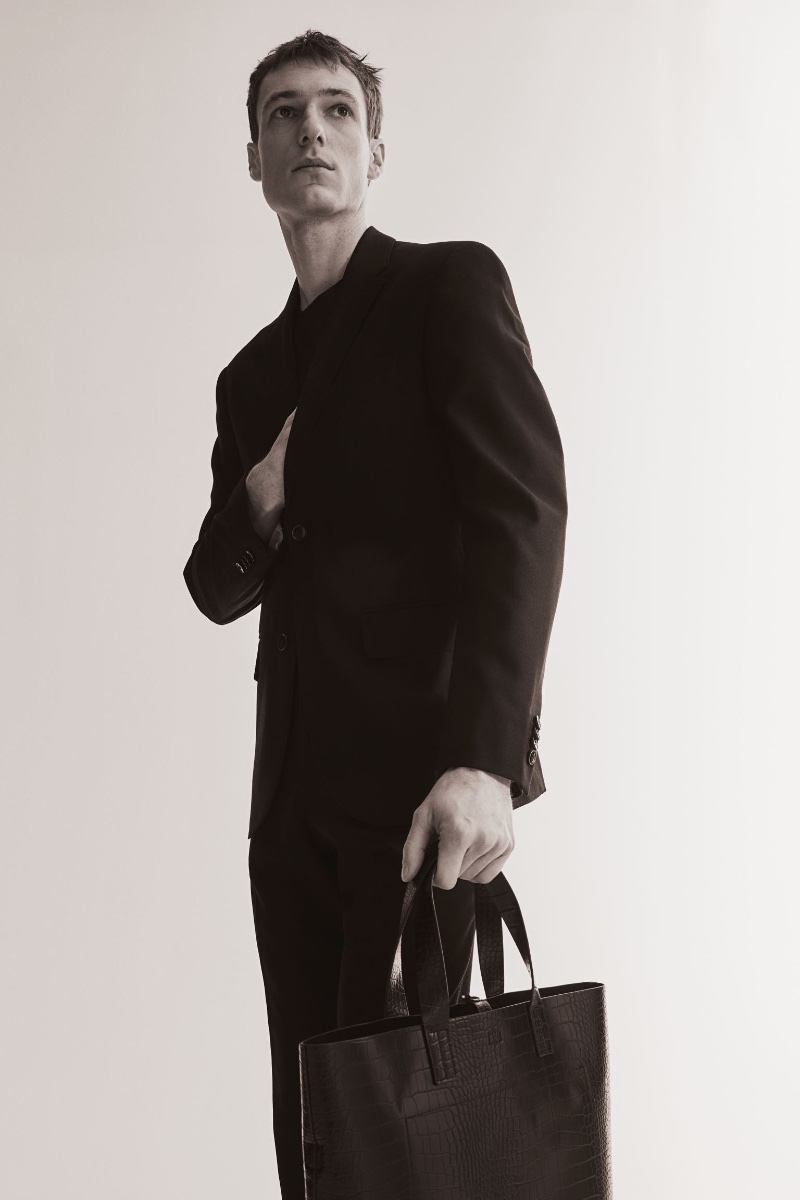 Tommaso de Benedictis models a classic black suit, paired with a leather tote from H&M. 