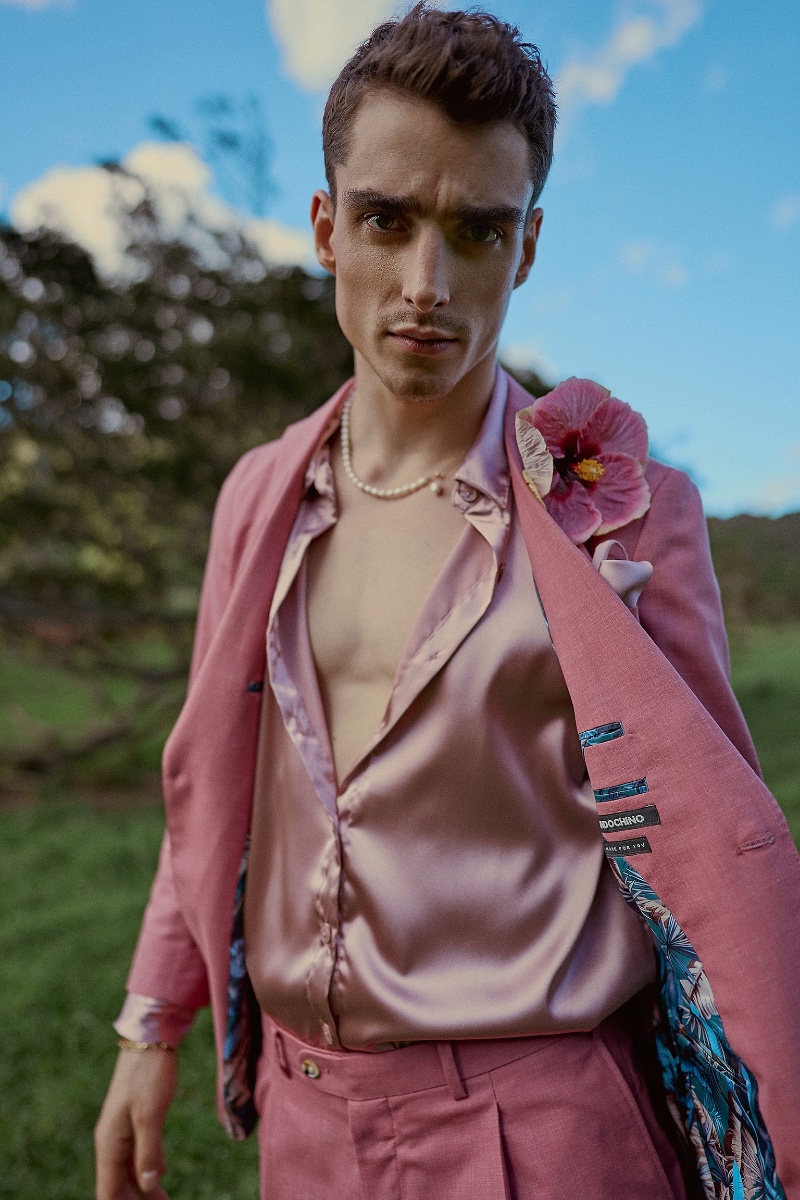 Model Kane Roberts dons a pink suit with a floral accent, bringing a bold edge to Indochino's spring-summer 2024 collection.