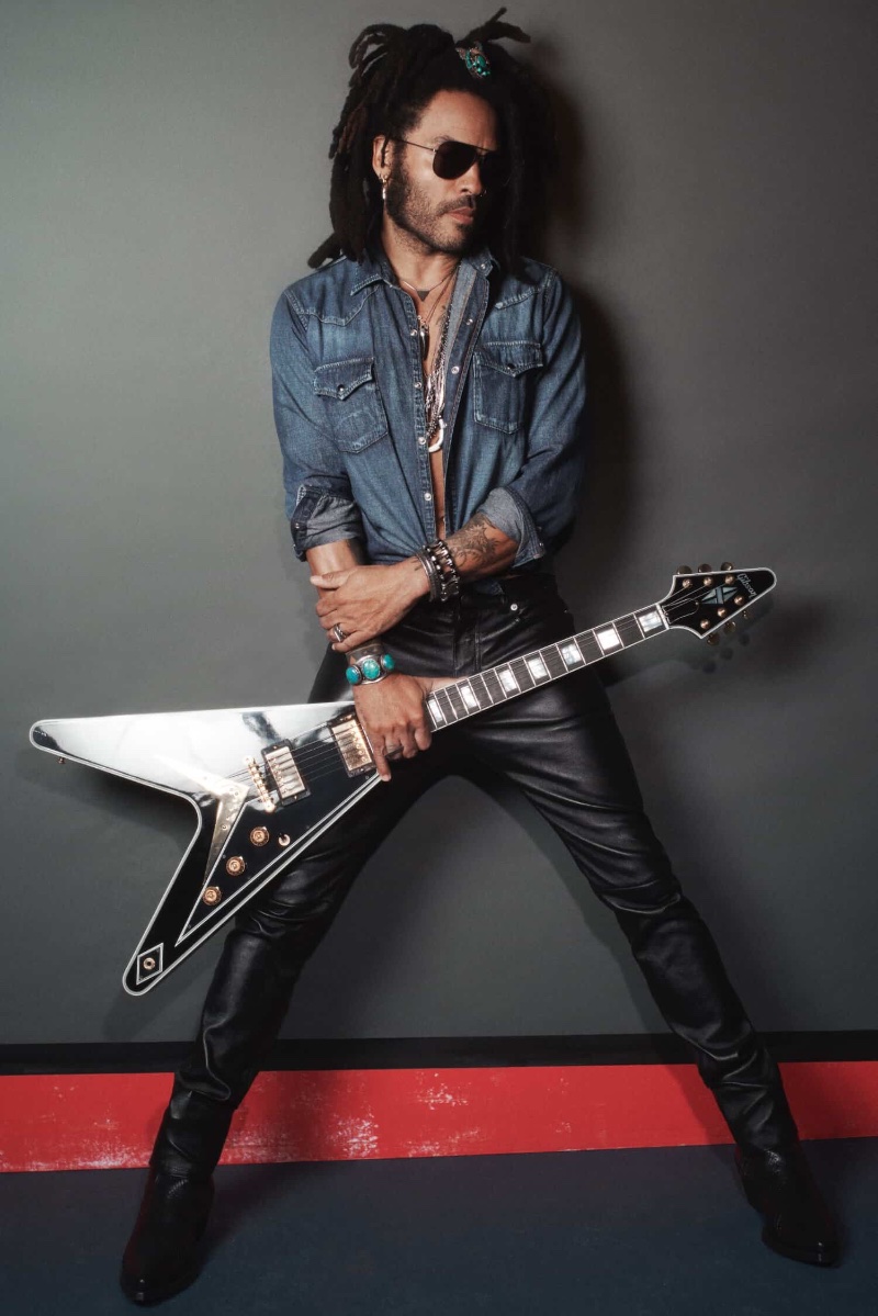 Photographed for Yves Saint Laurent's Y Elixir, Lenny Kravitz poses with his guitar, sporting a rugged denim shirt and leather pants.