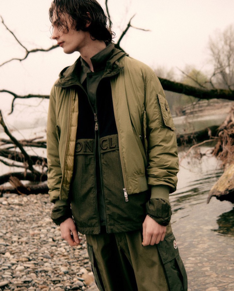 Freek Iven stands by a riverbank, clad in a layered Moncler ensemble from LuisaViaRoma.