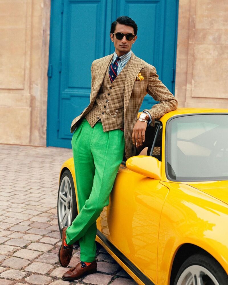 Rishi Robin wears Polo Ralph Lauren, showcasing a brown check and jacket and waistcoat with pleated trousers in a bright green. 