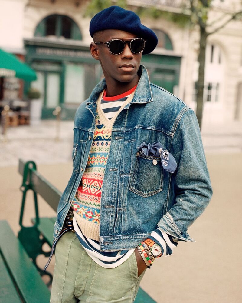 Cheikh Dia layers a denim jacket over a v-neck Fairisle sweater and long-sleeve striped tee. 