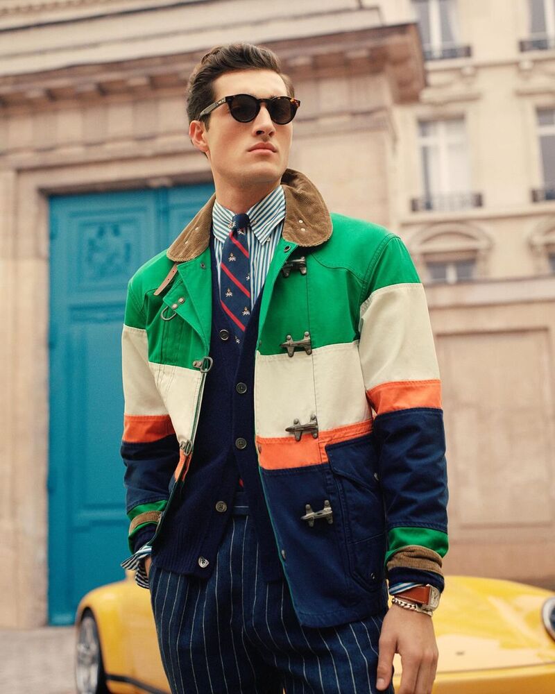 Embracing vibrant colors, Adam Sattrup wears Polo Ralph Lauren's color-blocked canvas jacket with pinstripe trousers.