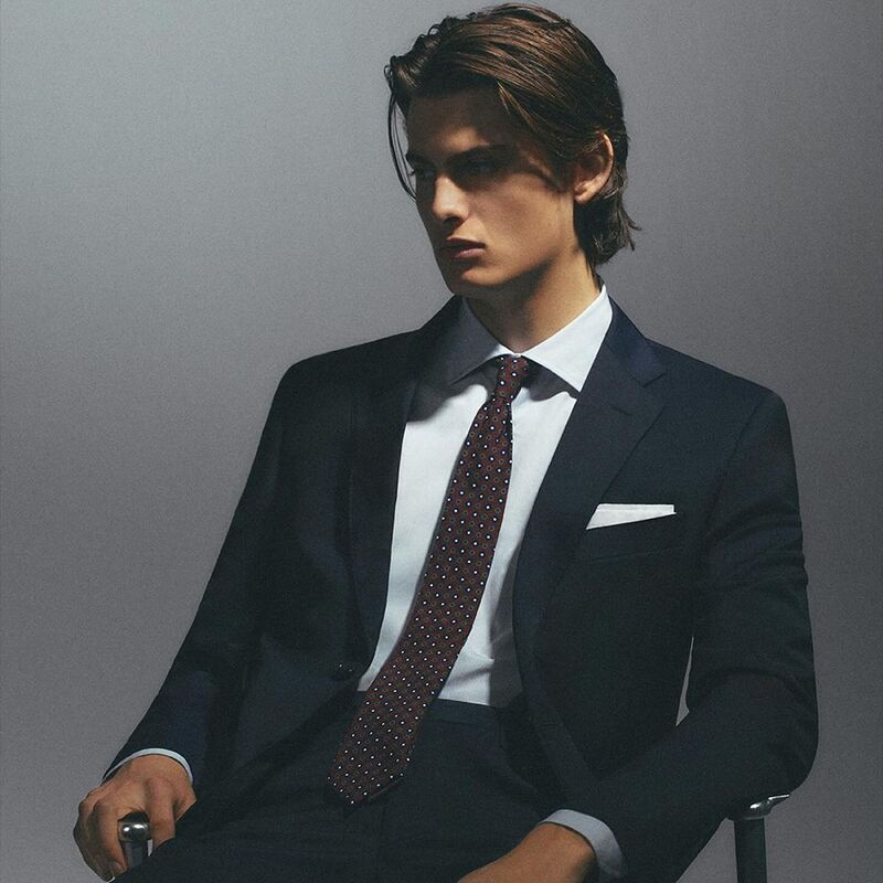 Contemplative, Mark Vanderloo Jr. is pictured in a sharp navy suit for Scalpers. 