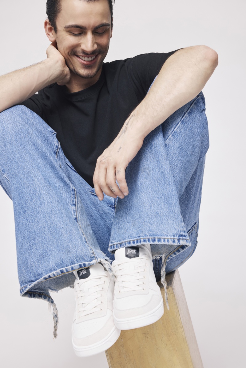 All smiles, Christian Cowan wears white sneakers for TOMS' Wear Good campaign for spring-summer 2024.