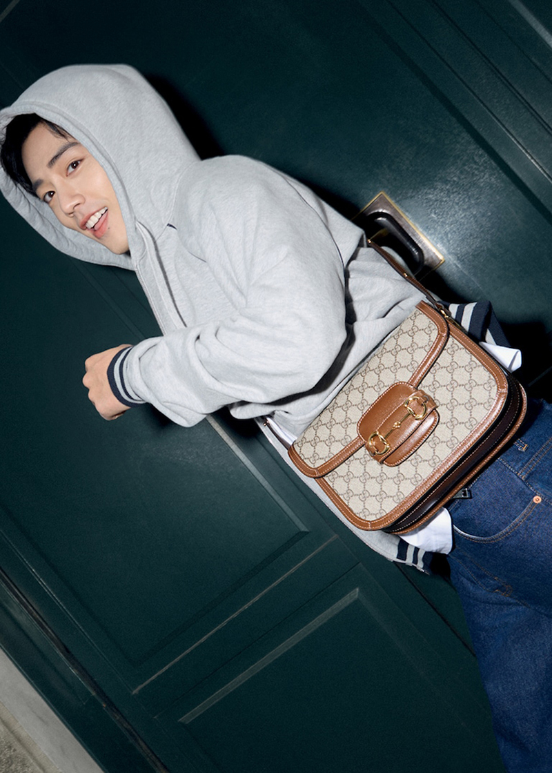 Enjoying a relaxed moment in a gray hoodie, Gucci brand ambassador Xiao Zhan stars in the Horsebit 1955 bag campaign.