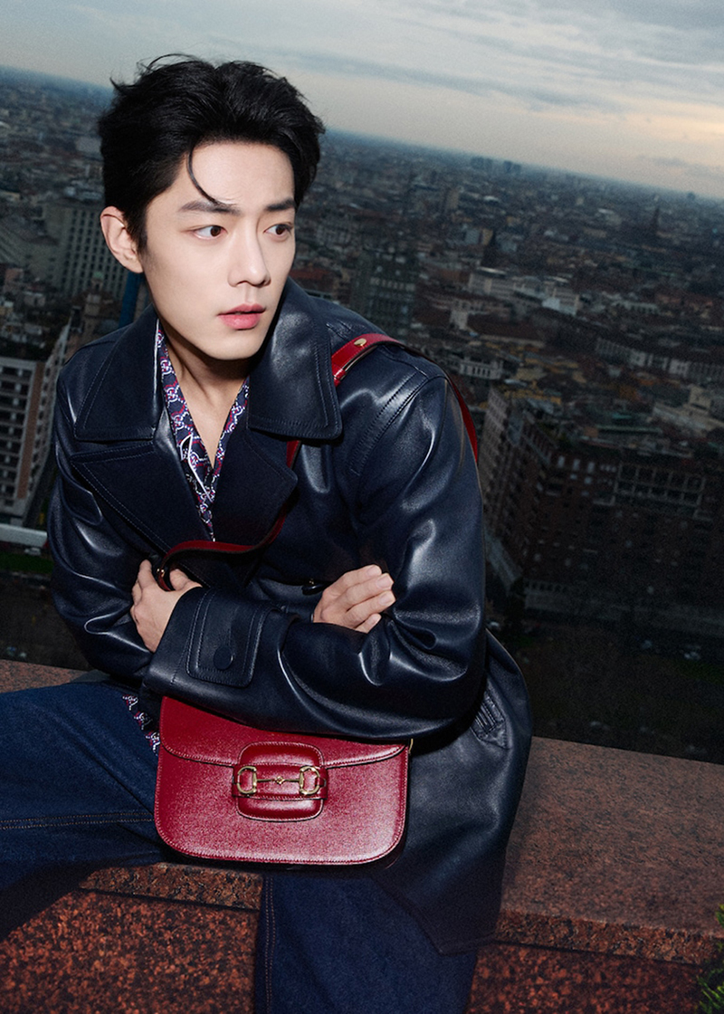 A modern vision in a leather jacket, Xiao Zhan sports a red Gucci Horsebit 1955 bag for the brand's newest advertisement.