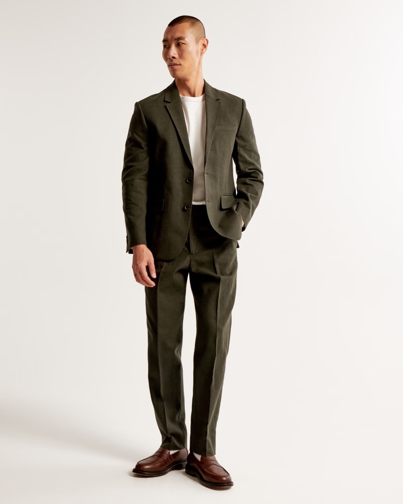 Showcasing a tailored fit, a dark olive green linen-blend suit is an excellent choice for a standout yet understated style.