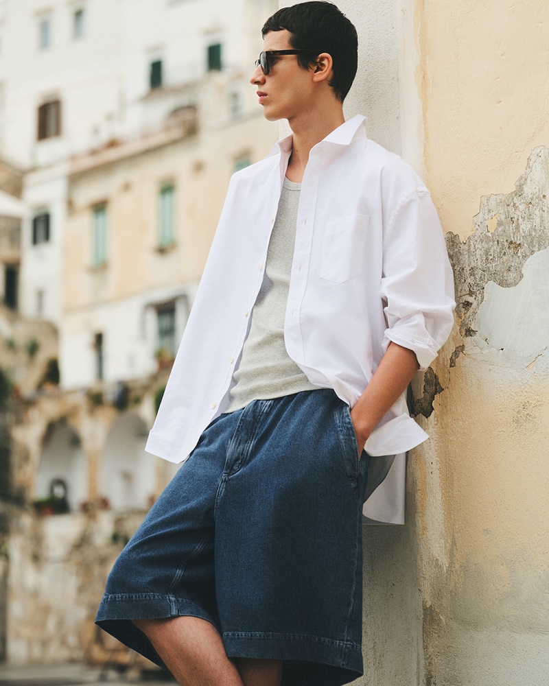 Model Kaplan Hani dons a COS wide Oxford shirt with denim shorts.