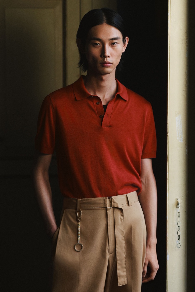 Standing out in a red polo and belted trousers, Taemin Park wears a COS look from the summer 2024 collection. 
