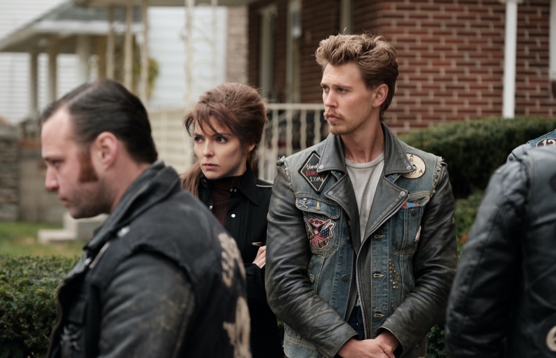 In The Bikeriders, Emory Cohen as Cockroach, Jodie Comer as Kathy, and Austin Butler as Benny are captured during a tense scene. 