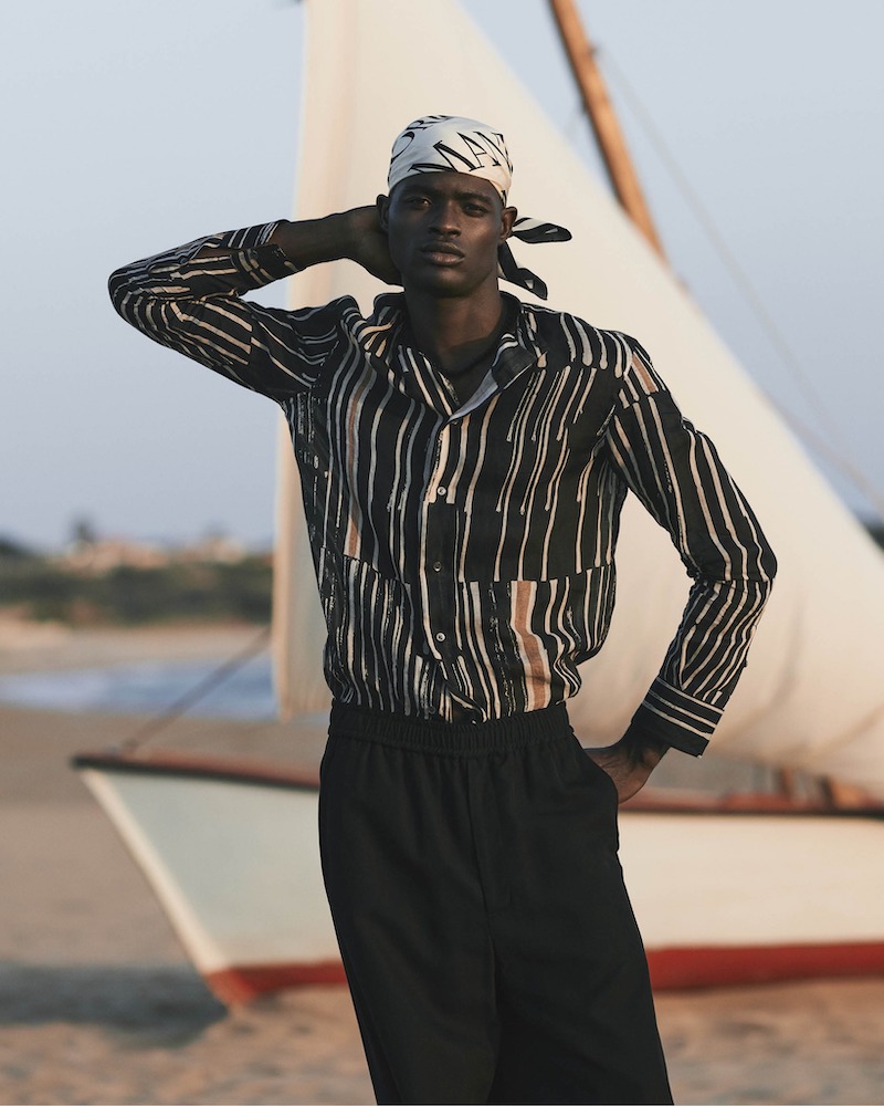 Kelvin Adewole is a chic vision in an Emporio Armani outfit with a silk scarf. 