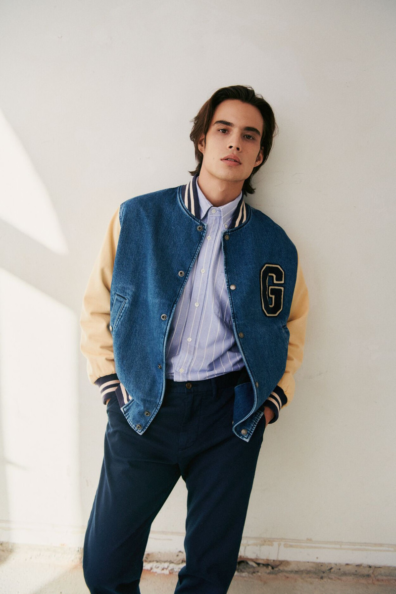 Louis Baines wears a GANT denim bomber jacket with a striped shirt.