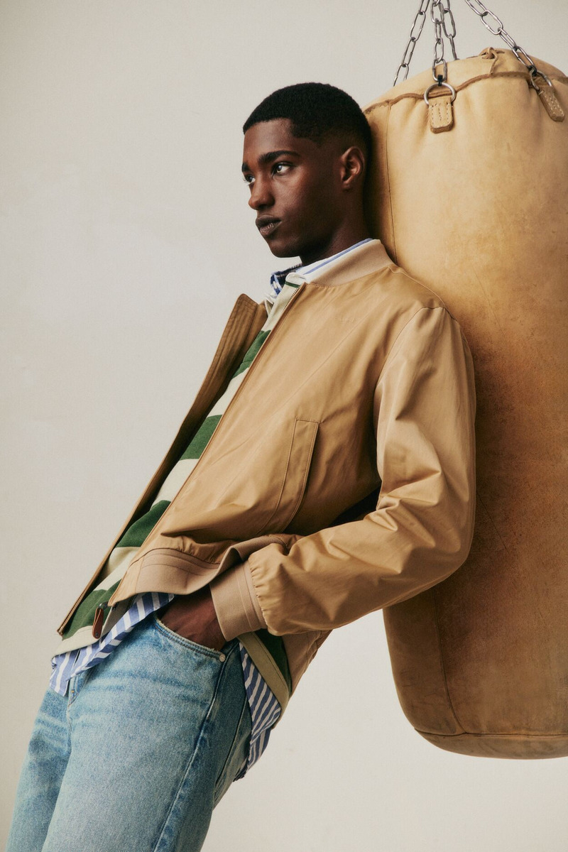 Diogo Gomes sports a GANT bomber jacket with a rugby shirt, jeans, and a striped poplin shirt.