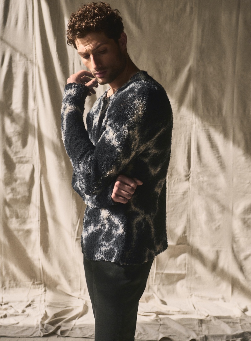 Isaac Churchill rocks a graphic sweater from John Varvatos' pre-fall 2024 collection.