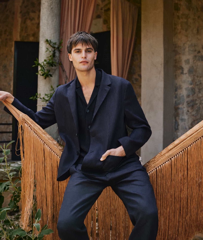 Parker van Noord dons a navy Massimo Dutti linen suit over a short-sleeve knit cardigan.