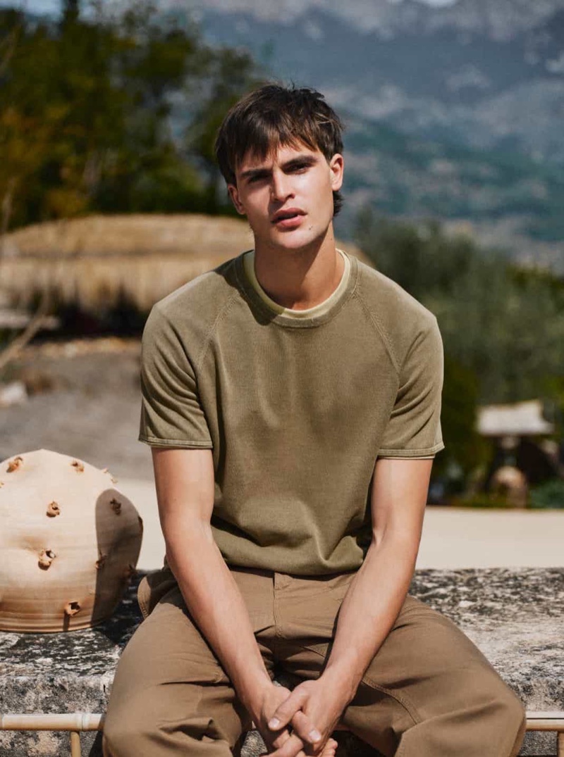 Dutch model Parker van Noord layers a short-sleeve knit over a t-shirt with linen and cotton trousers. 
