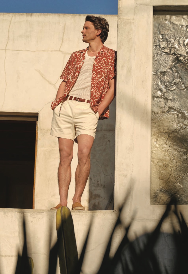 Showcasing summer style, Simon Nessman dons a Todd Snyder short-sleeve shirt with 5" Officer shorts, an O-ring braided belt, and suede esp