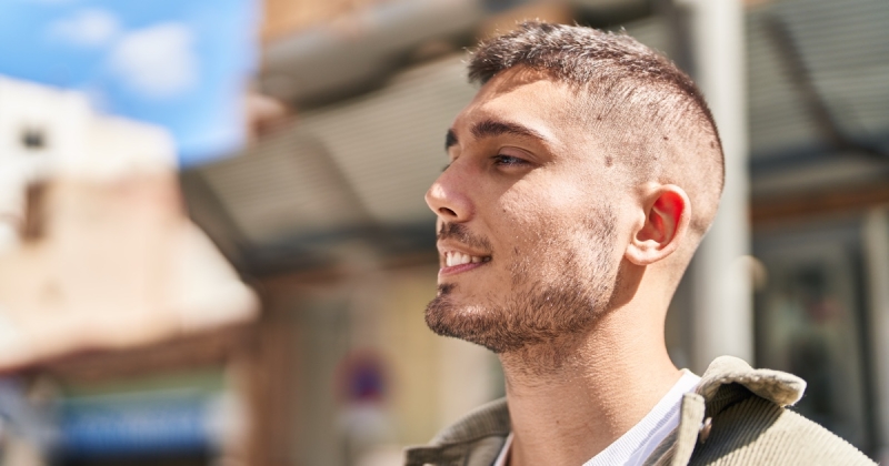Young hispanic man smiling confident standing at street