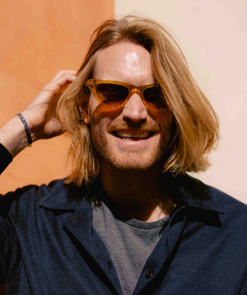 man wearing orange cateye wayfarer sunglasses that are maximalist
