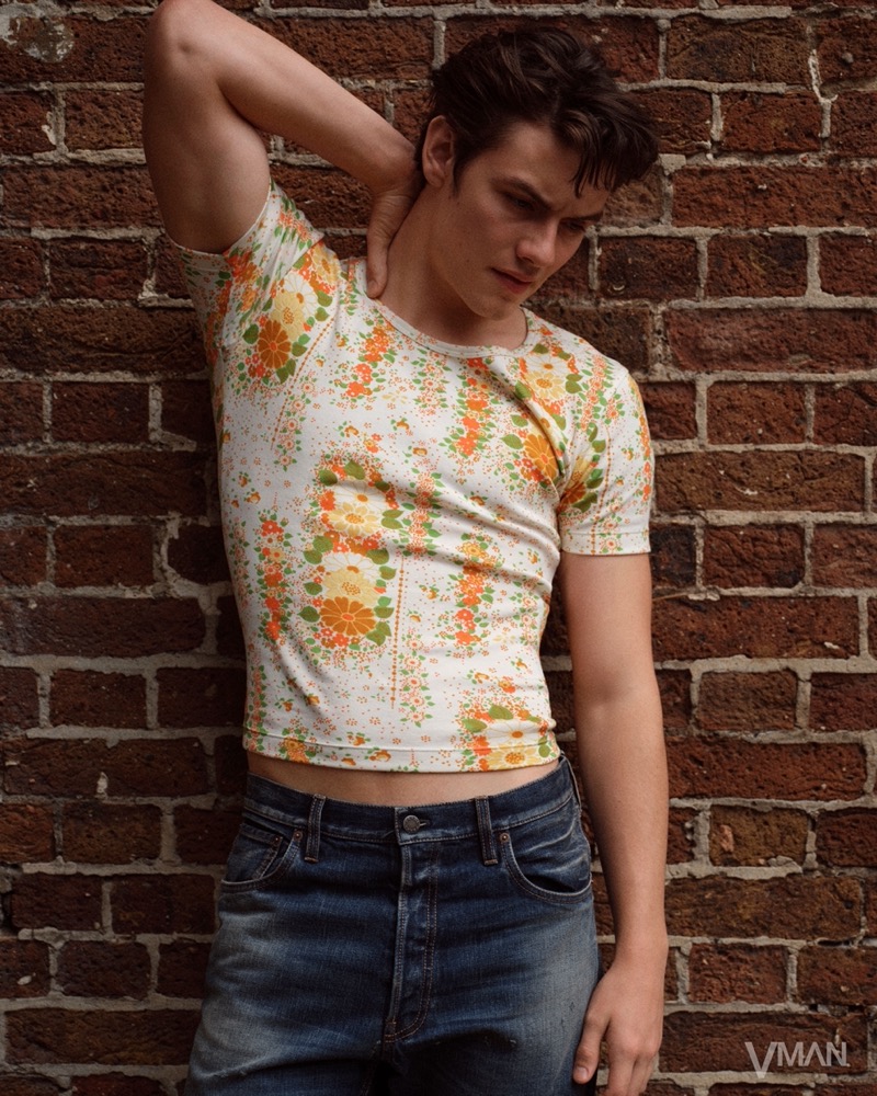 Louis Partridge wears a floral print top and denim by Prada.