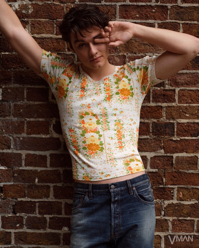 Louis Partridge wears a floral print top and denim by Prada for VMAN.