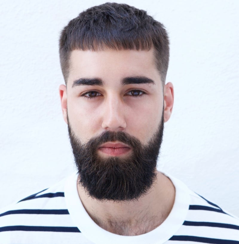 Man with a textured crop haircut featuring short choppy hair and fringe.