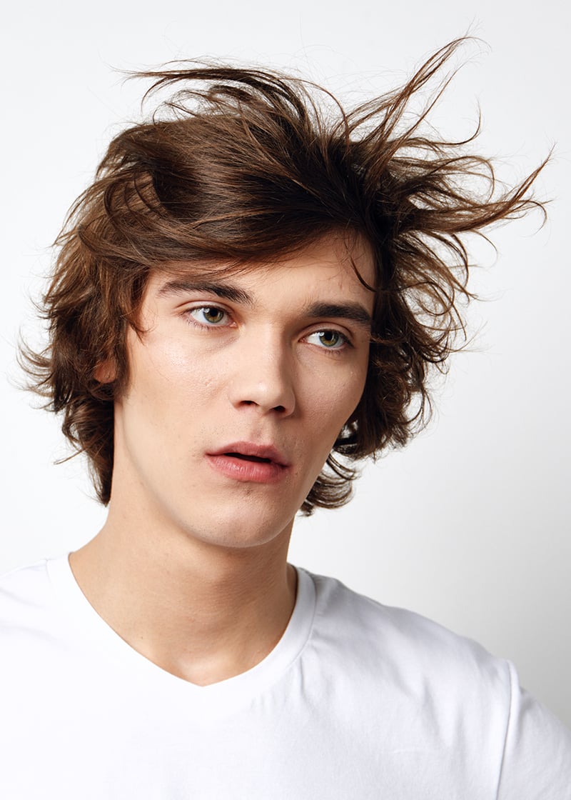 Man with a long textured fringe hairstyle featuring layered hair and natural movement.