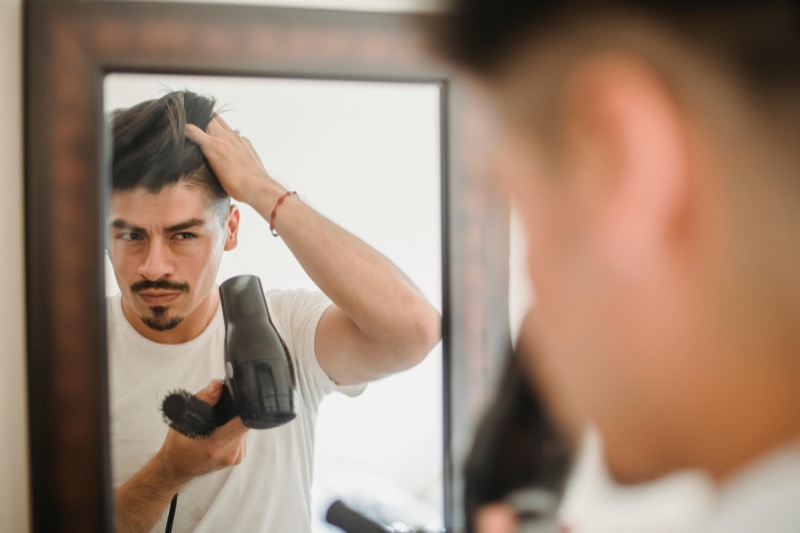 Man blowdrying hair mirror