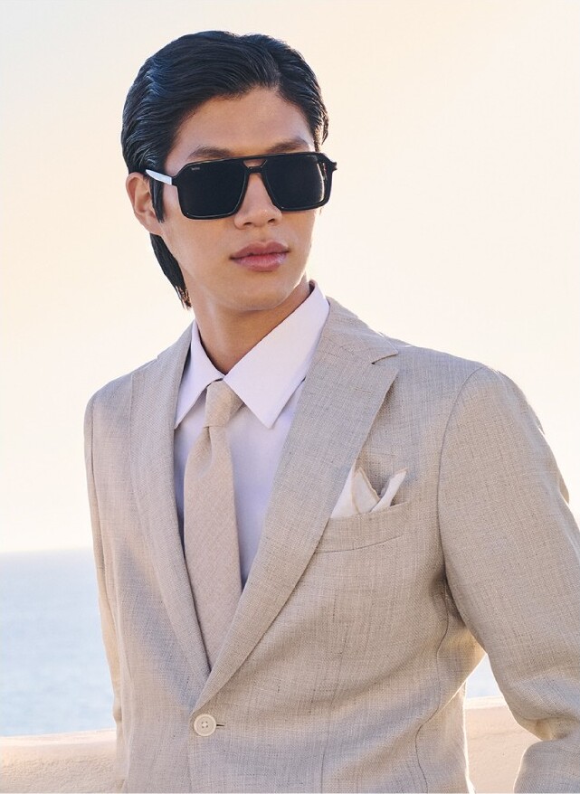 Sanggun wears a beige linen suit with a matching tie