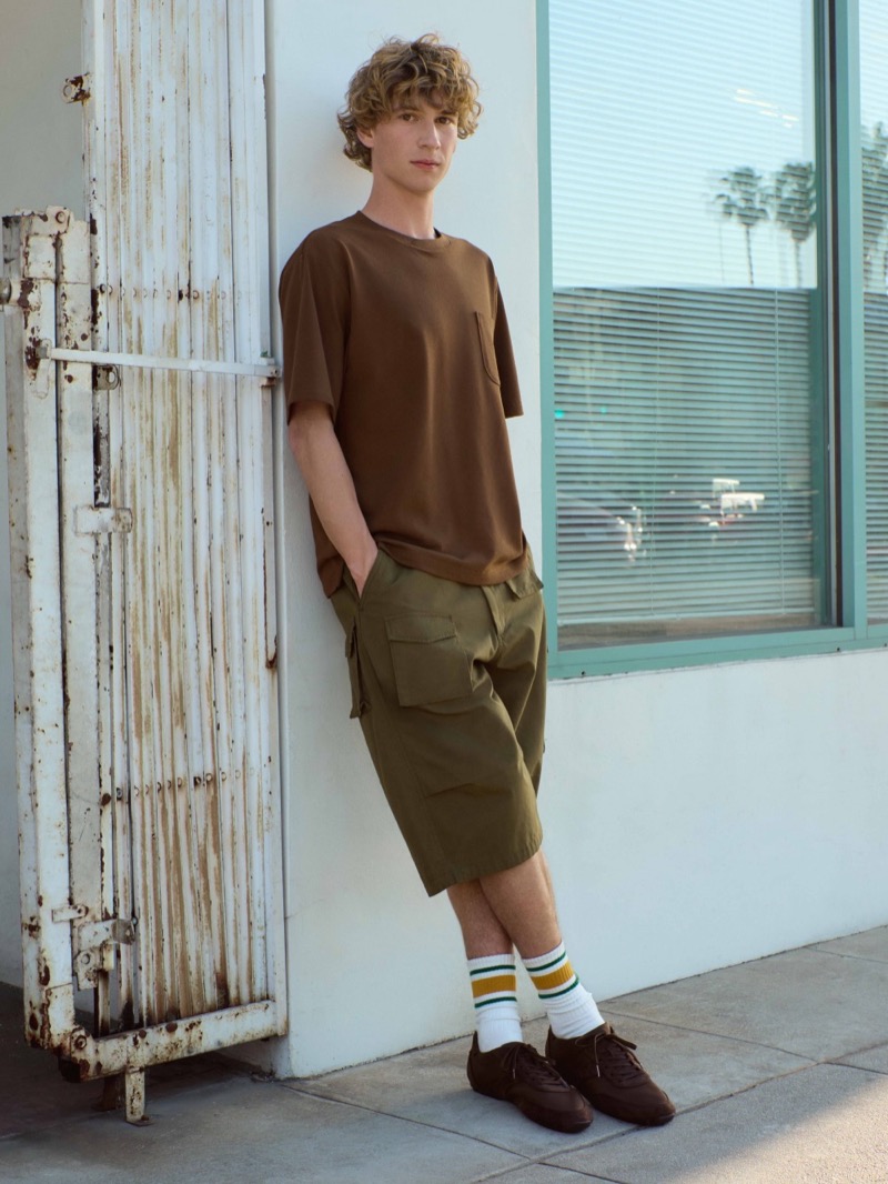 Model wears a brown pocket tee with olive green utility shorts