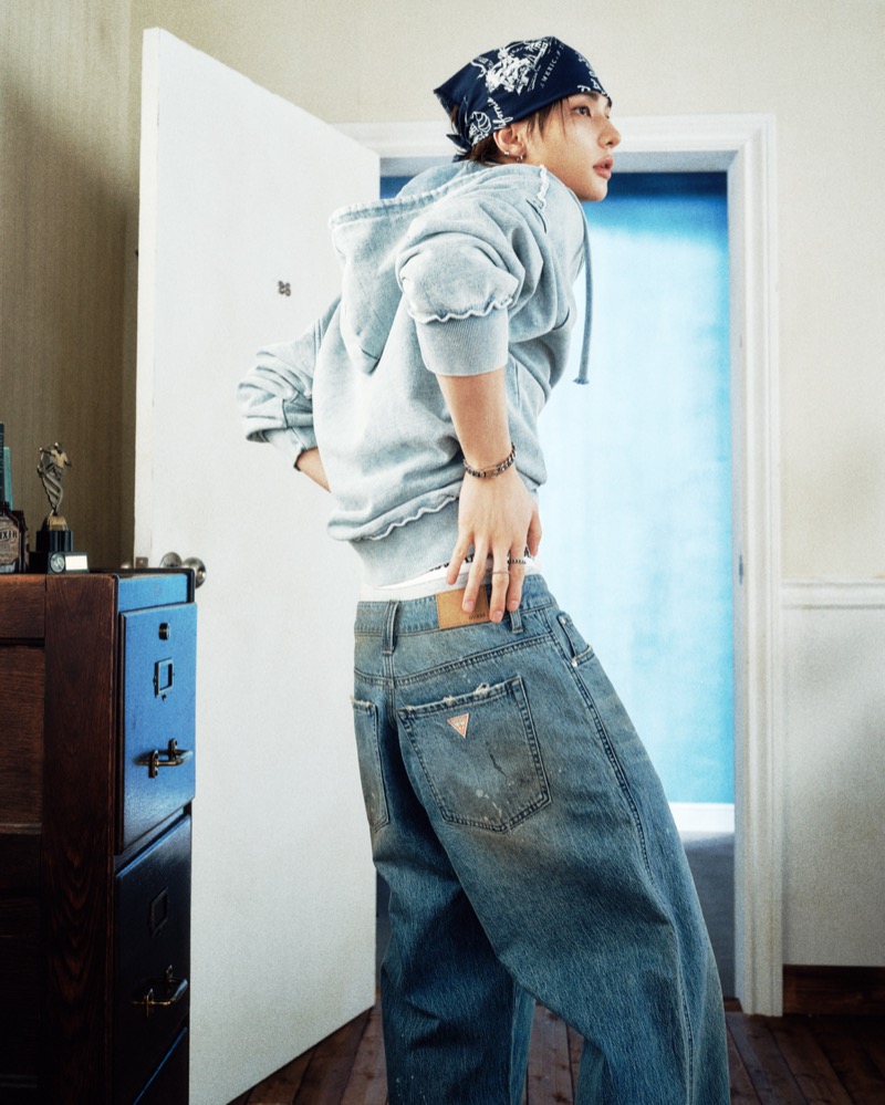 Hyunjin photographed from behind wearing baggy jeans and a gray hoodie