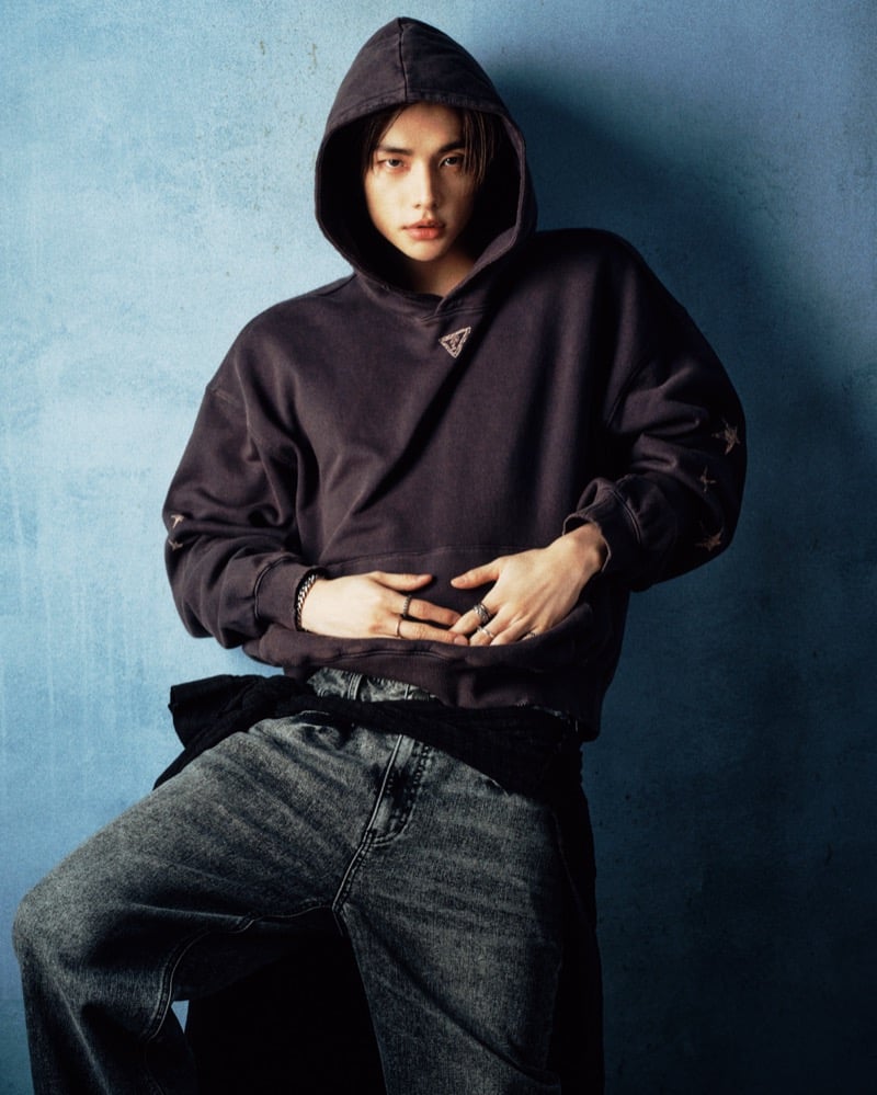 Hyunjin wears a black hoodie with distressed jeans