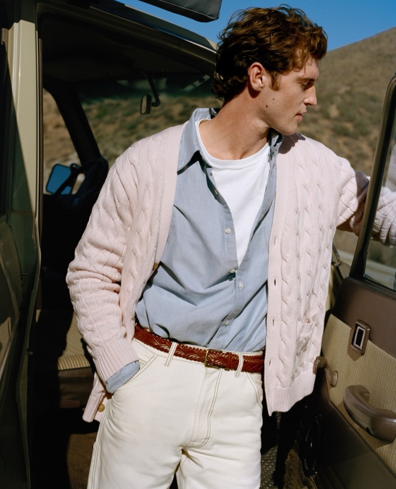 Model wears a pink cable-knit cardigan sweater with an Oxford shirt and off-white carpenter jeans from J.Crew