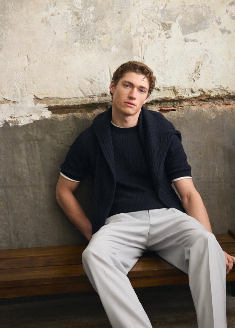 Valentin wears a short-sleeve cable-knit sweater with chinos