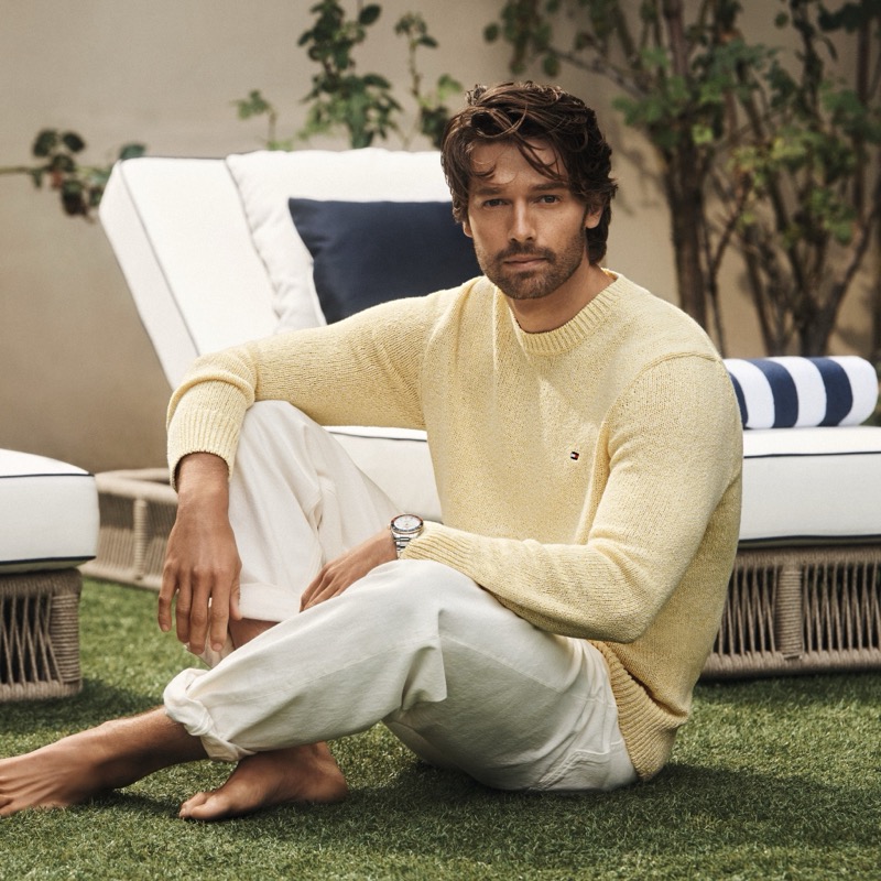 Patrick Schwarzenegger wears a butter yellow sweater with white pants from Tommy Hilfiger's spring 2026 collection