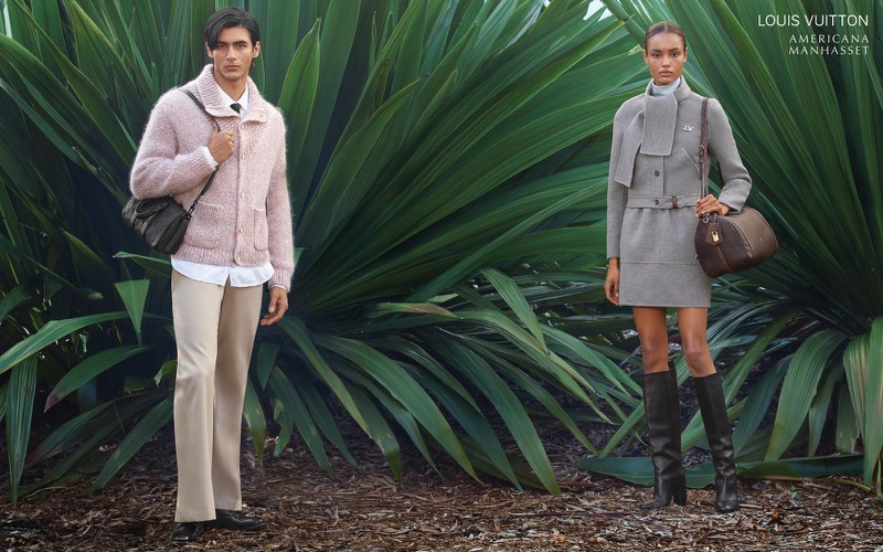 Akbar wears a Louis Vuitton pink cardigan over a white shirt with cream trousers and a crossbody bag alongside Ana in a grey belted outfit