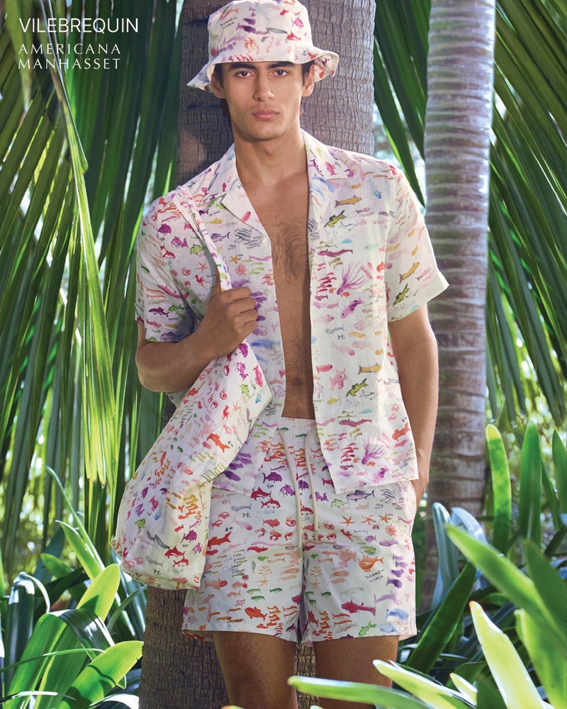 Akbar wears a Vilebrequin watercolor-print camp shirt with matching swim trunks and a bucket hat