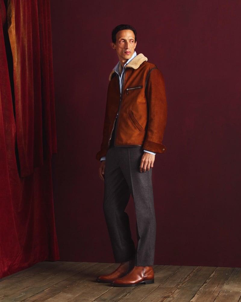 Naoki wears a burnt-amber shearling-collar leather jacket over a light shirt with charcoal trousers and cognac Chelsea boots
