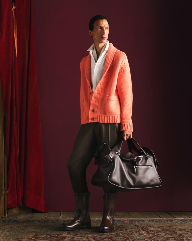 Naoki wears a coral shawl-collar cardigan over a white shirt with olive trousers, dark brown mid-calf boots, and a dark leather bag