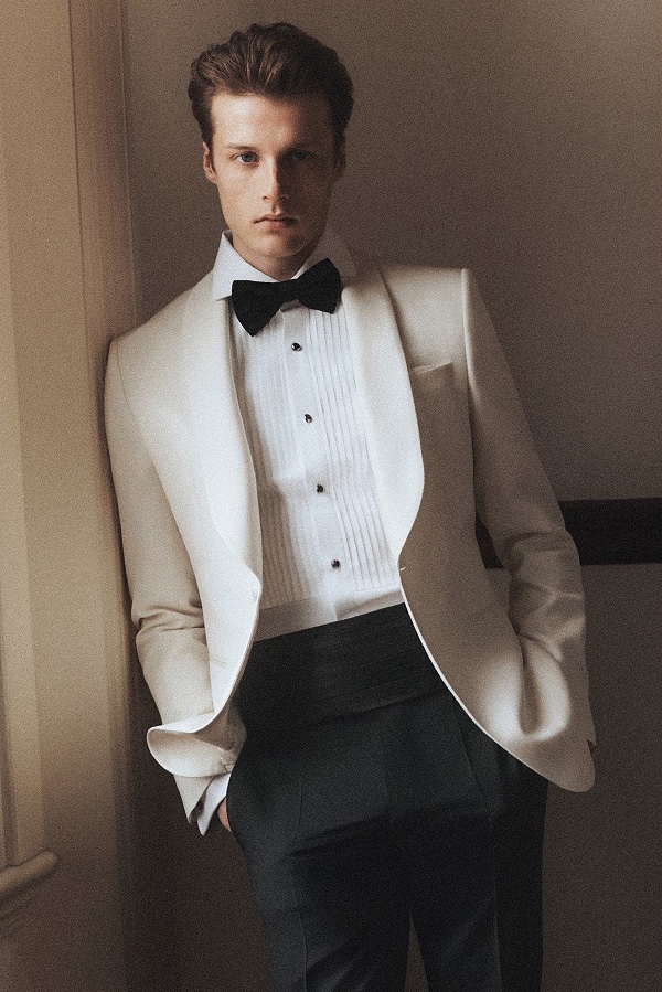 Hugh wears a BOSS Made to Order ivory dinner jacket with a black bow tie