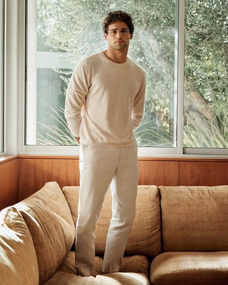 Giacomo wears a cream linen crewneck sweater with relaxed trousers and clear-frame glasses for Calvin Klein spring 2026