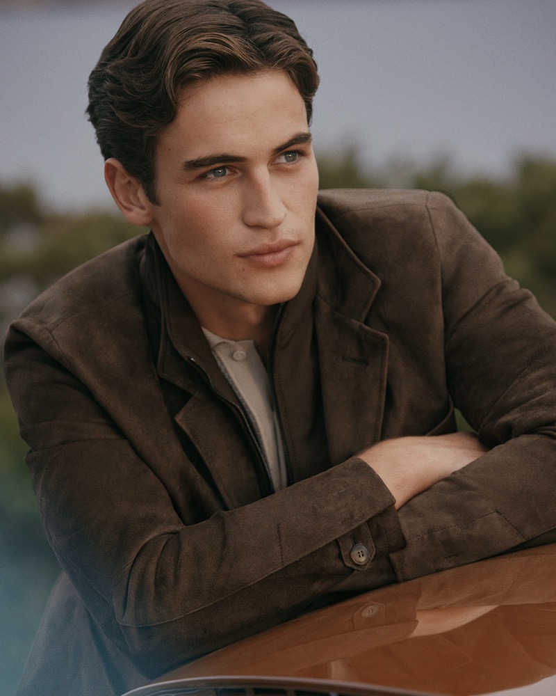 Luca leans on the hood of a vintage car in a brown suede jacket for Canali's spring-summer 2026 campaign
