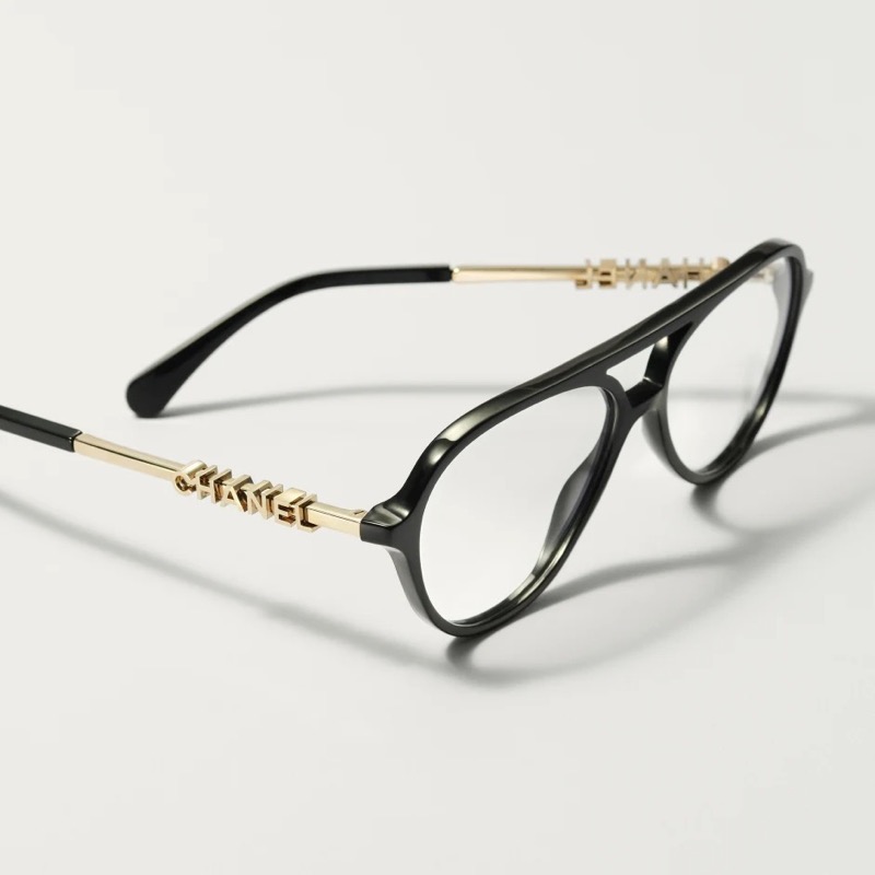 Chanel black pilot eyeglasses with a double bridge and gold arms spelling CHANEL in raised lettering
