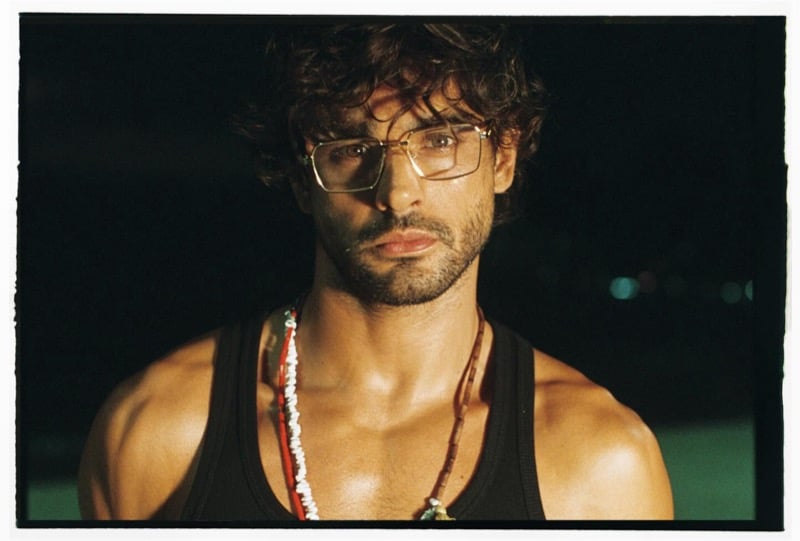 Close-up portrait of Marlon at night in optical glasses, a black tank, and layered beaded shell necklaces for Dsquared2's spring-summer 2026 campaign