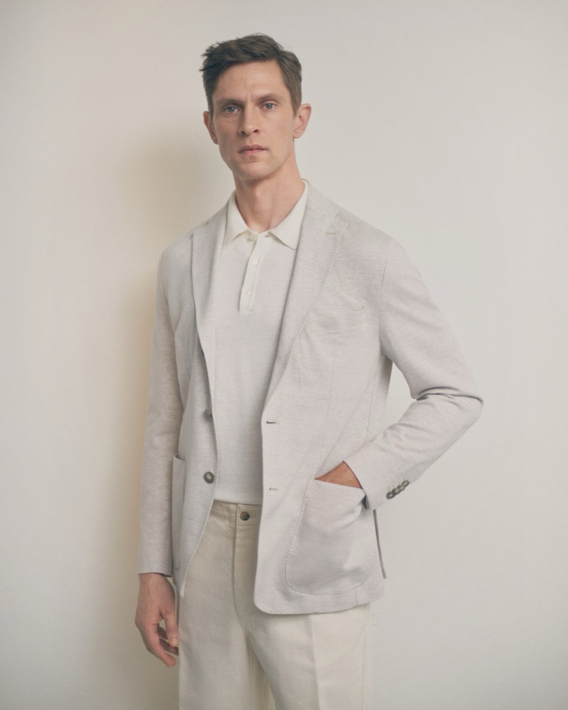 Mathias wears an unstructured Eton blazer over a polo shirt