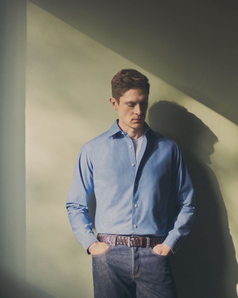 Mathias wears a blue Eton cotton shirt with a woven leather belt