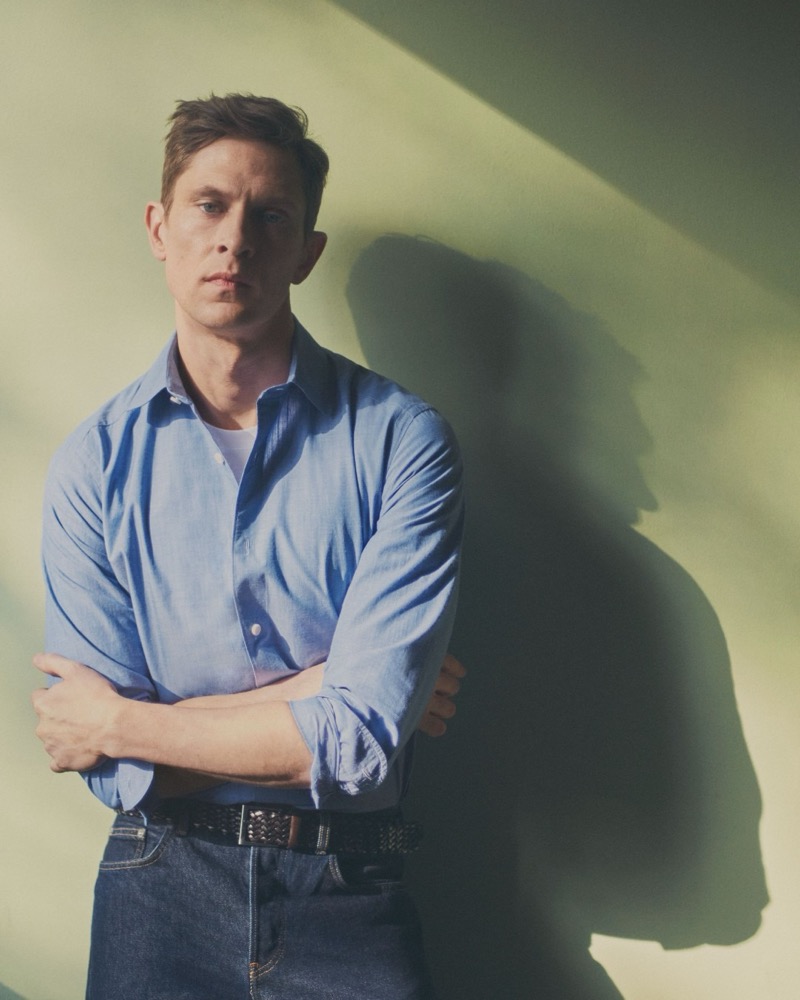 Mathias crosses his arms in a blue Eton cotton shirt